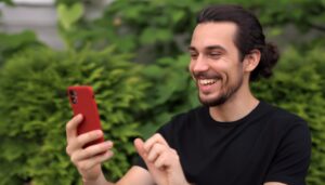 un homme content utilise un iphone